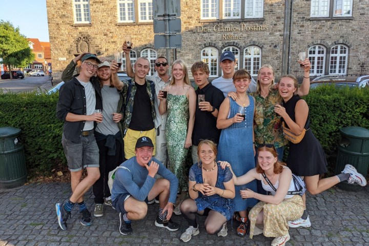 a group of people posing for a photo in front of a building