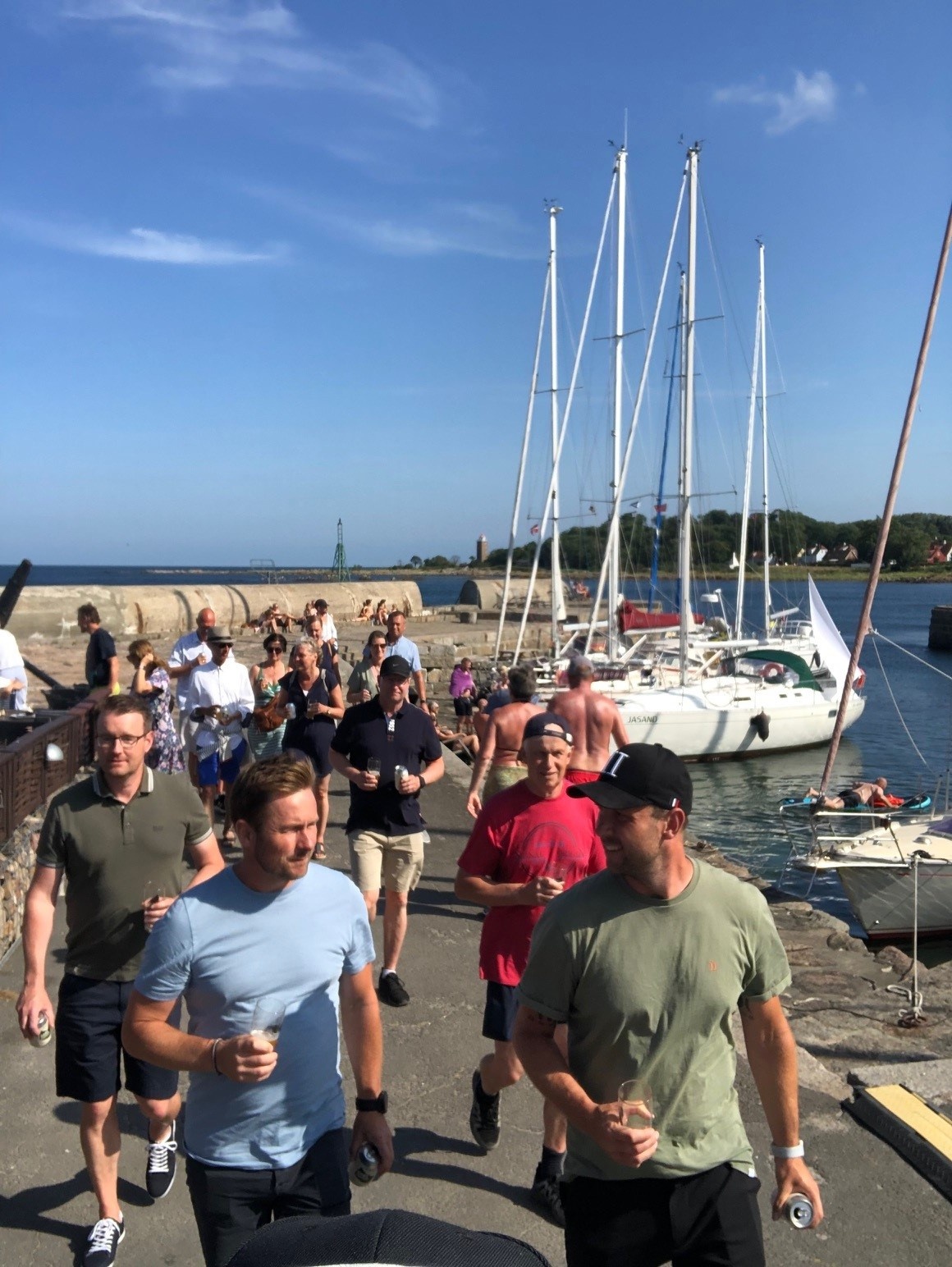 Bornholm BeerWalk (Svaneke) Image 1 a group of people standing next to a body of water