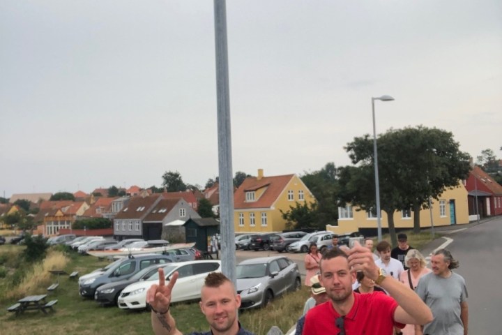 a group of people standing on the side of a road
