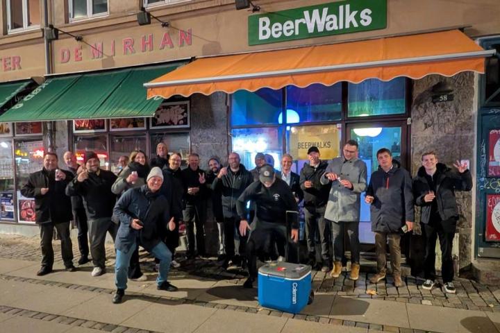 Group of people posing outside a bar with a 'BeerWalks' sign.