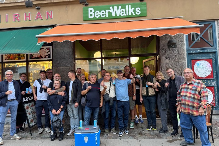Group of people posing outside a store called BeerWalks.